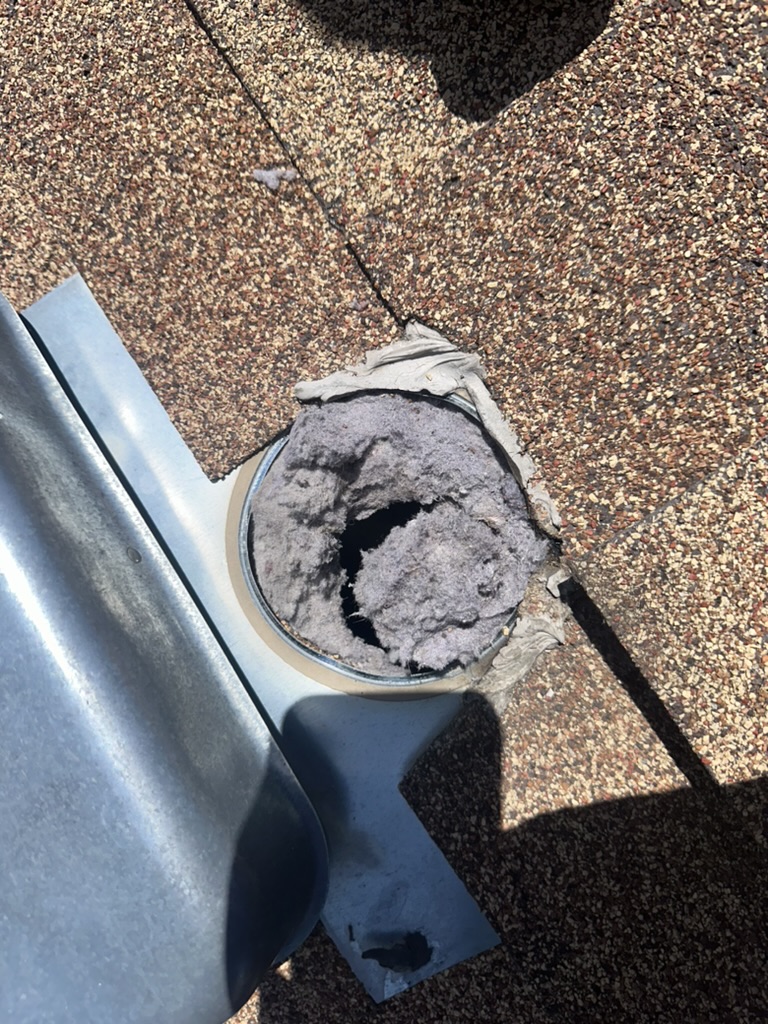 Clogged dryer vent exit on roof showing lint buildup